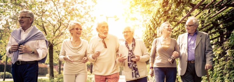 Vertical shot of six elderly adults walking together outside